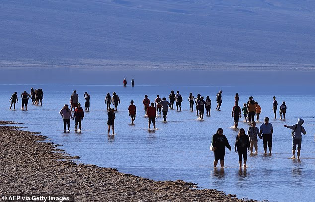It is not the first time the lake has returned, in February last year after the remnants of a hurricane combined with an atmospheric river to deluge the site. Pictured: Tourists wade in the lake in on February 18, 2024