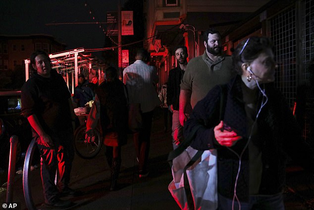 Pedestrians walk in the dark on Hayes Street after a major power outage in San Francisco