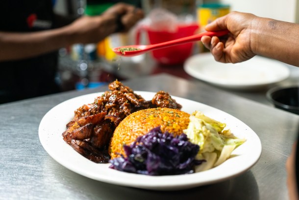 Chefs at AfroEatz plate an order of Liberian jollof rice and chicken wings, one of the most popular dishes at the new Sacramento restaurant. Louis Byrant III, OBSERVER