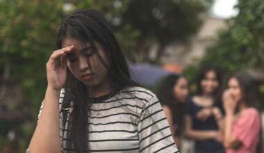 Asian woman upset in the foreground with a group of women excluding her in the background