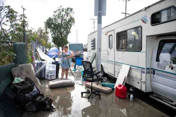 "It's going to be catastrophic without funding," says Saundra Macpherson, 53, who says she knows 20 people who have been housed as she hoses down bedding and pillows from the camper she shares with her sister and five dogs in Pacoima on Thursday, Sept. 18, 2025. Los Angeles County homeless service agencies are warning of deep funding cuts in reducing homelessness. (Photo by Sarah Reingewirtz, Los Angeles Daily News/SCNG)
