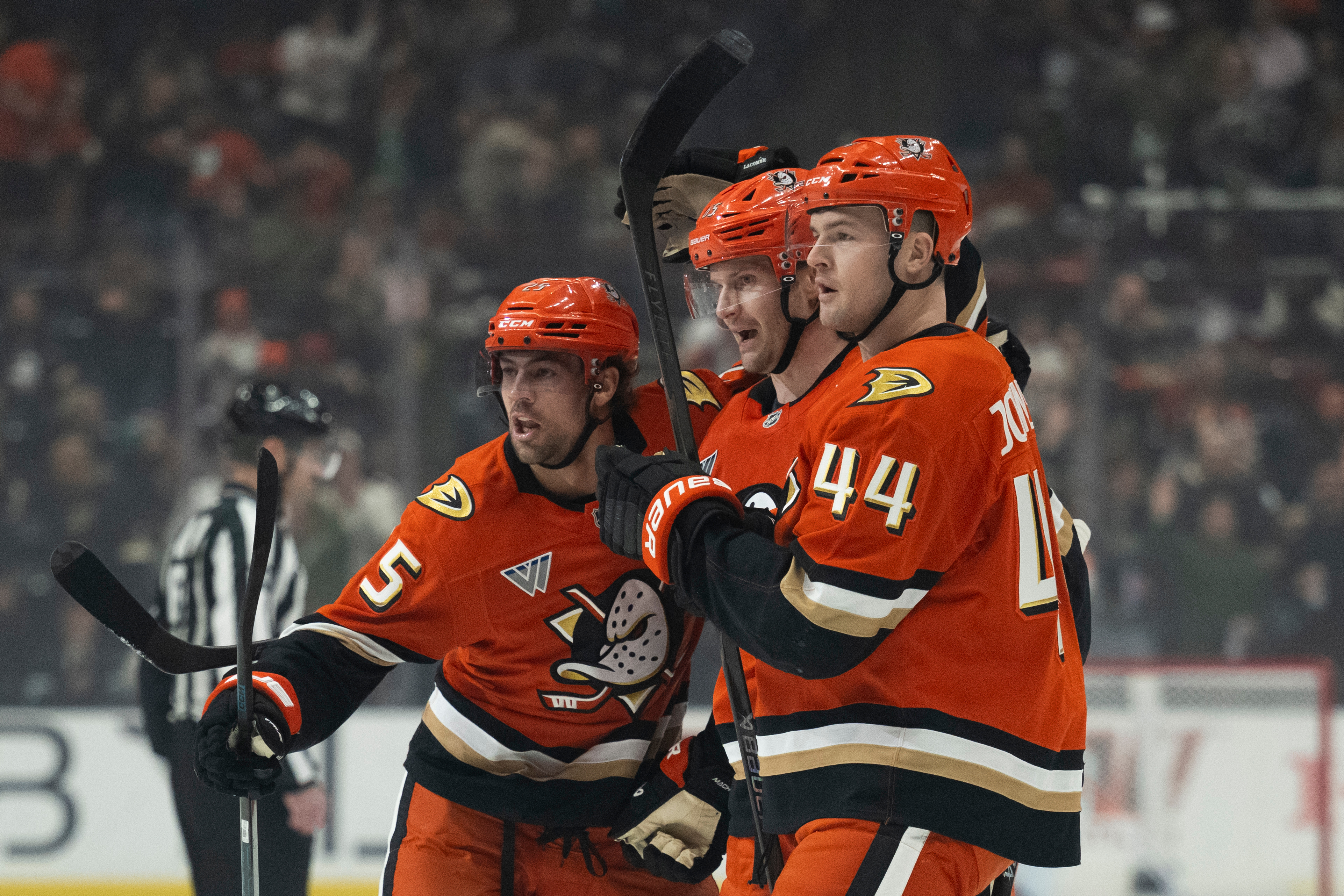 Ducks center Ryan Poehling, left, defenseman Jacob Trouba, center, and...
