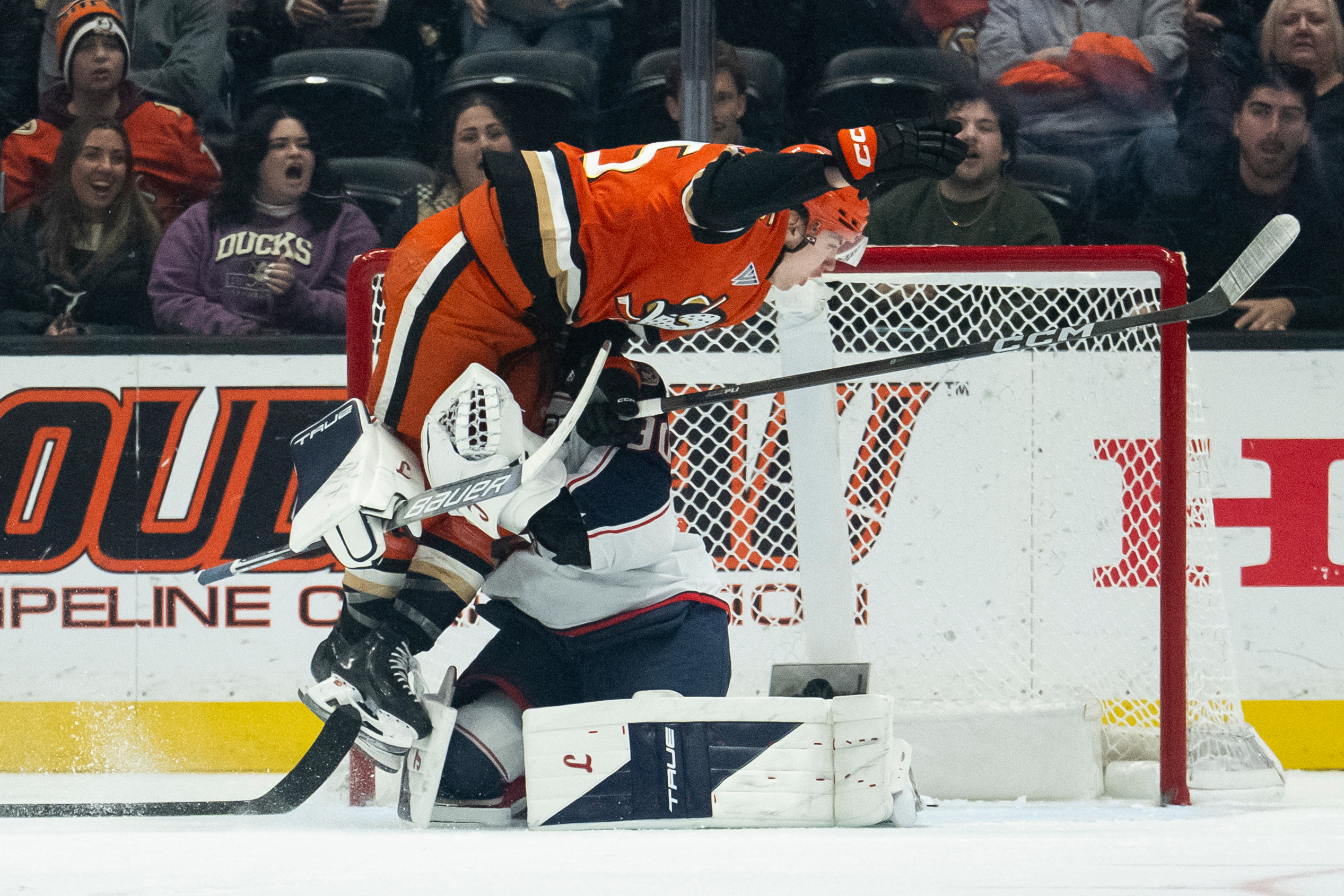 Ducks right wing Beckett Sennecke, top, skates into Columbus Blue...