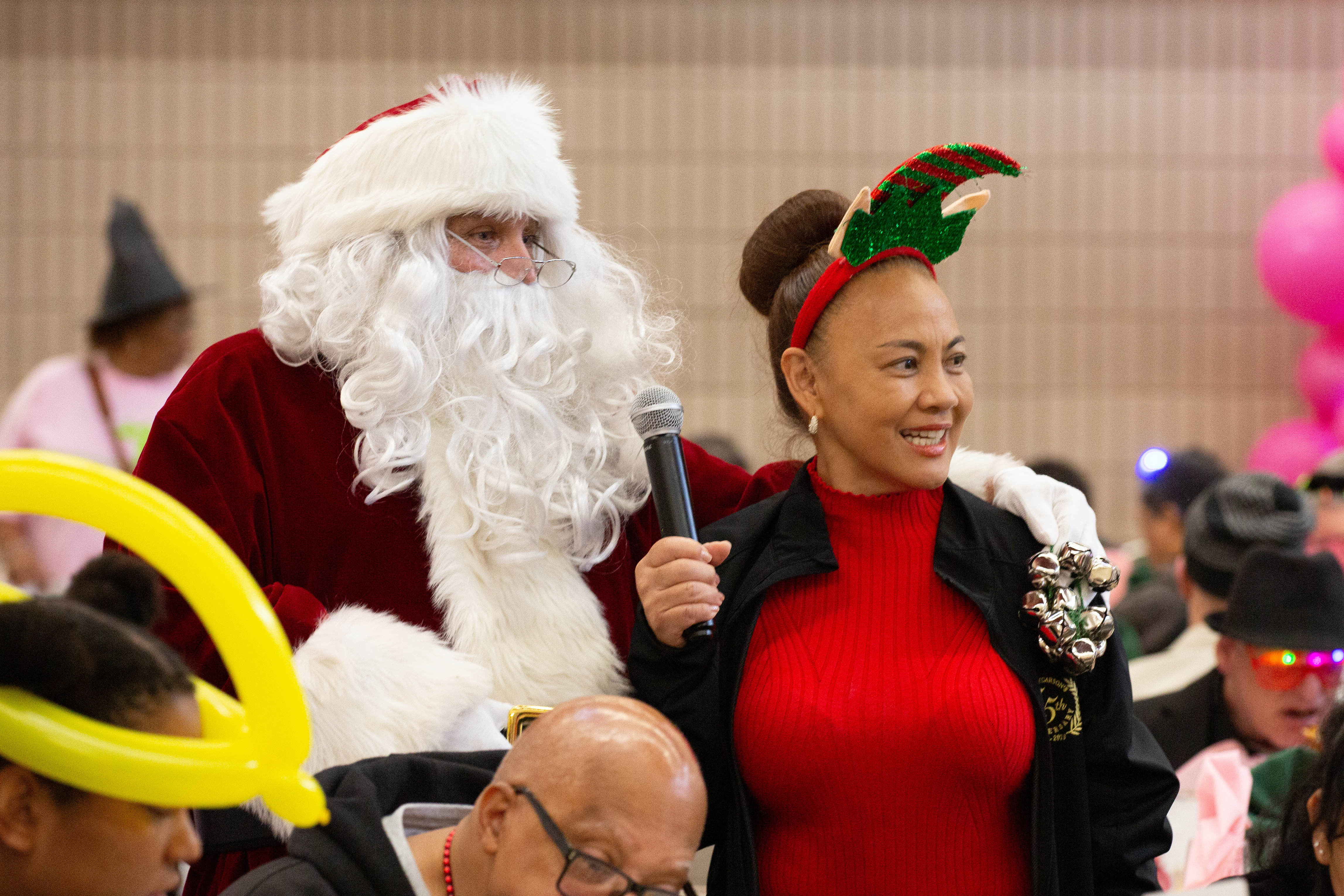 Santa Claus, left, stands with Councilmember Arleen Rojas during the...