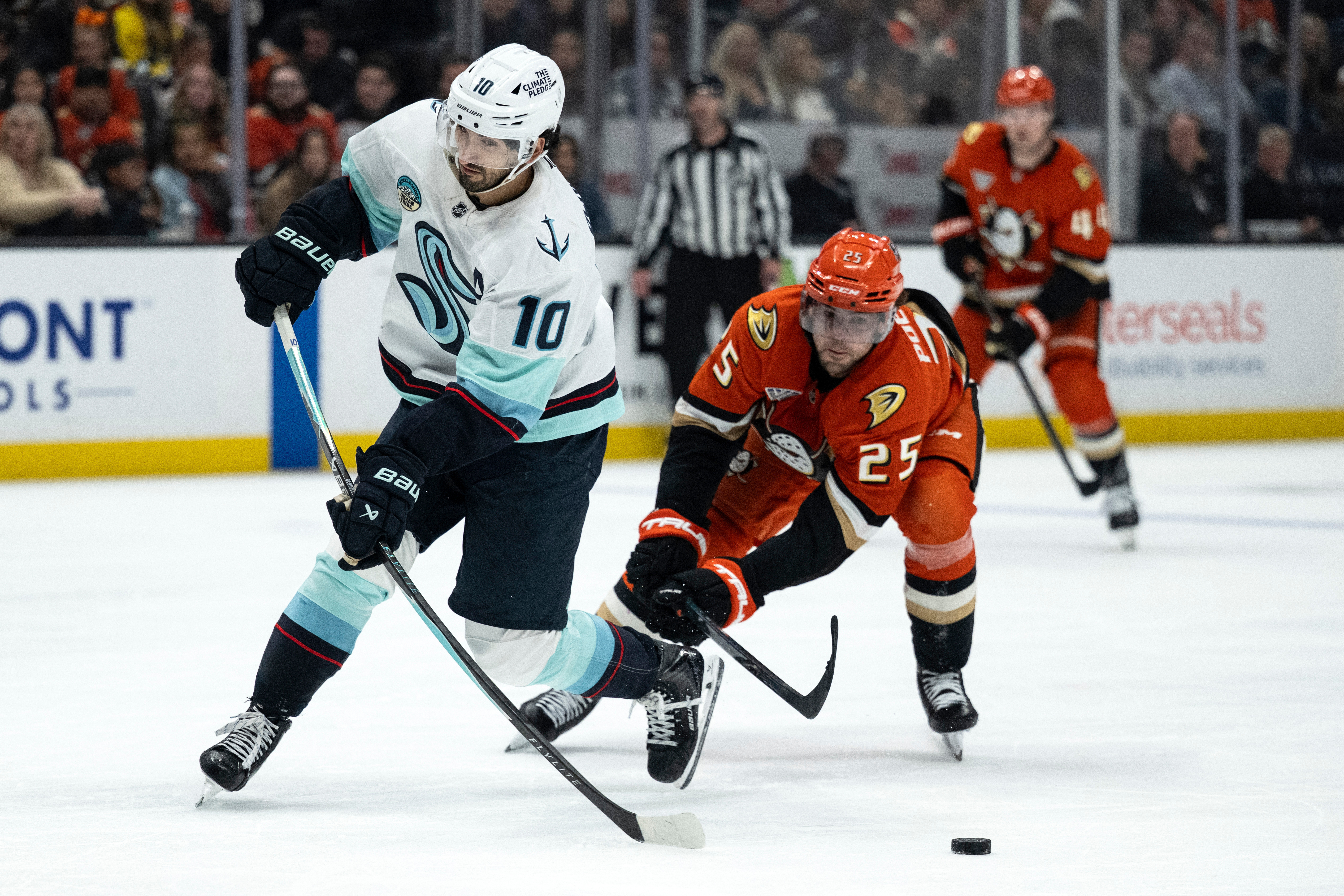 Ducks center Ryan Poehling, right, stops Seattle Kraken center Matty...