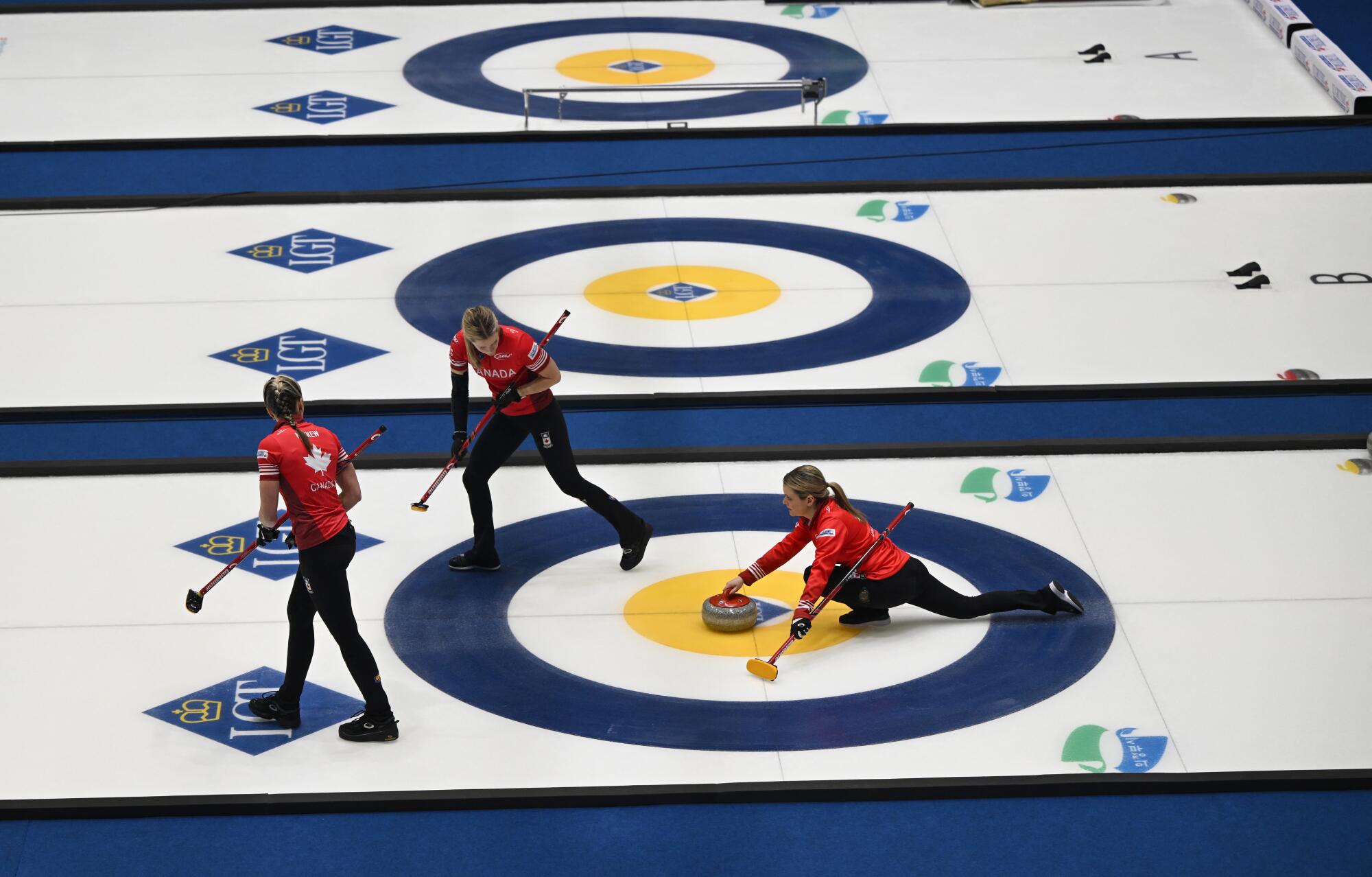 Canada's Tracy Fleury (R) releases the stone during a gold medal match against Switzerland.