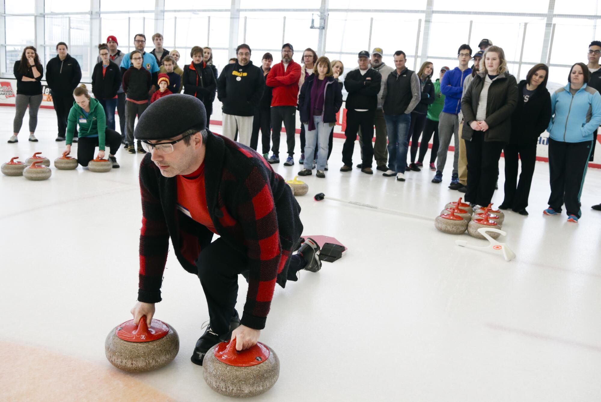 Aksarban Curling Club president Steve Taylor demonstrates how to push off the hack to deliver a stone.