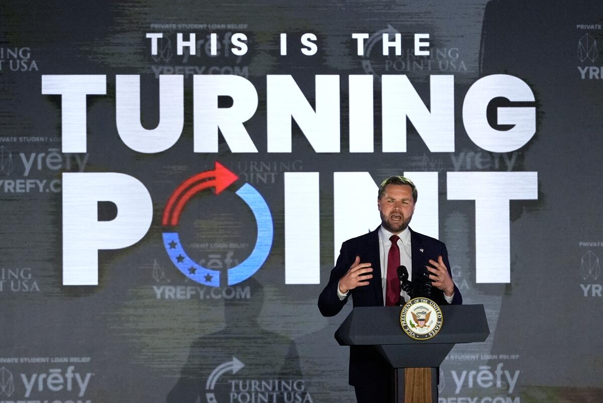 Vice President JD Vance speaks at a college campus event in front of a poster reading "This Is the Turning Point." 