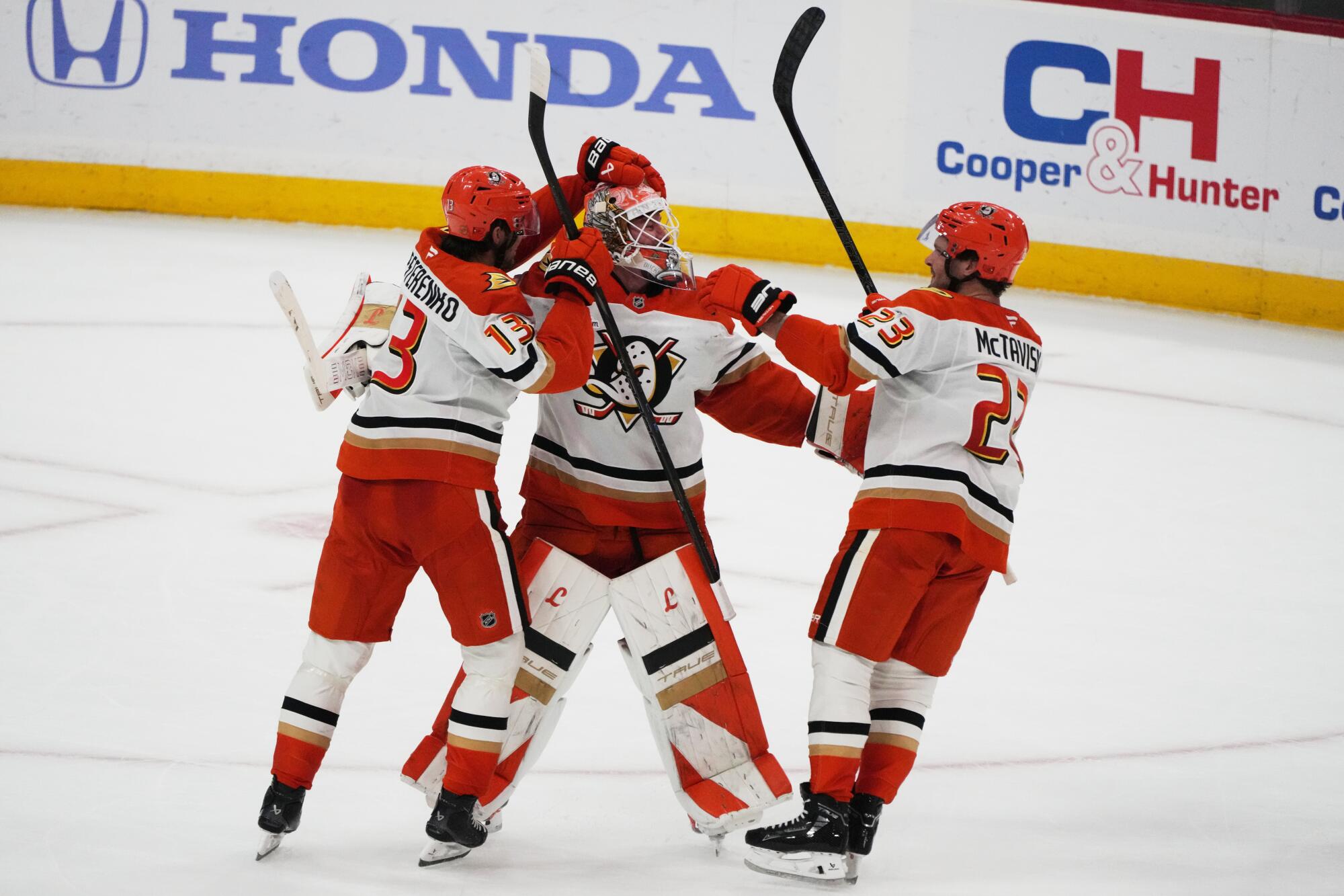 Ducks goaltender Lukas Dostal is congratulated by Nikita Nesterenko and Mason McTavish after blocking a shot.