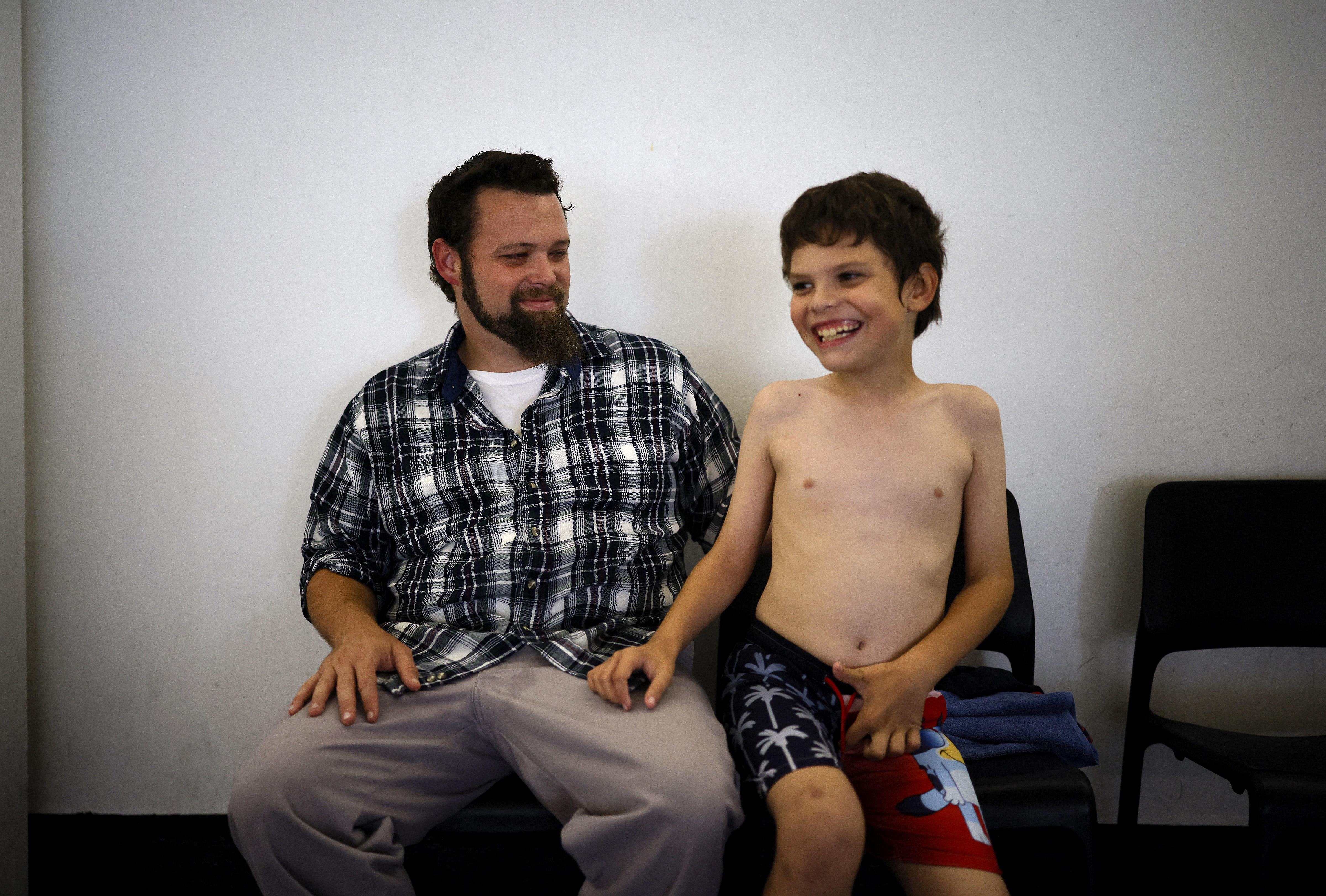 Lucas Foreman, 9, from San Jose, waits with his father...