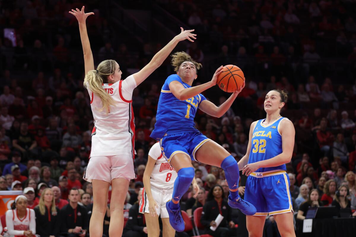 UCLA guard Kiki Rice, center, goes up to shoot between Ohio State guard Kylee Kitts.