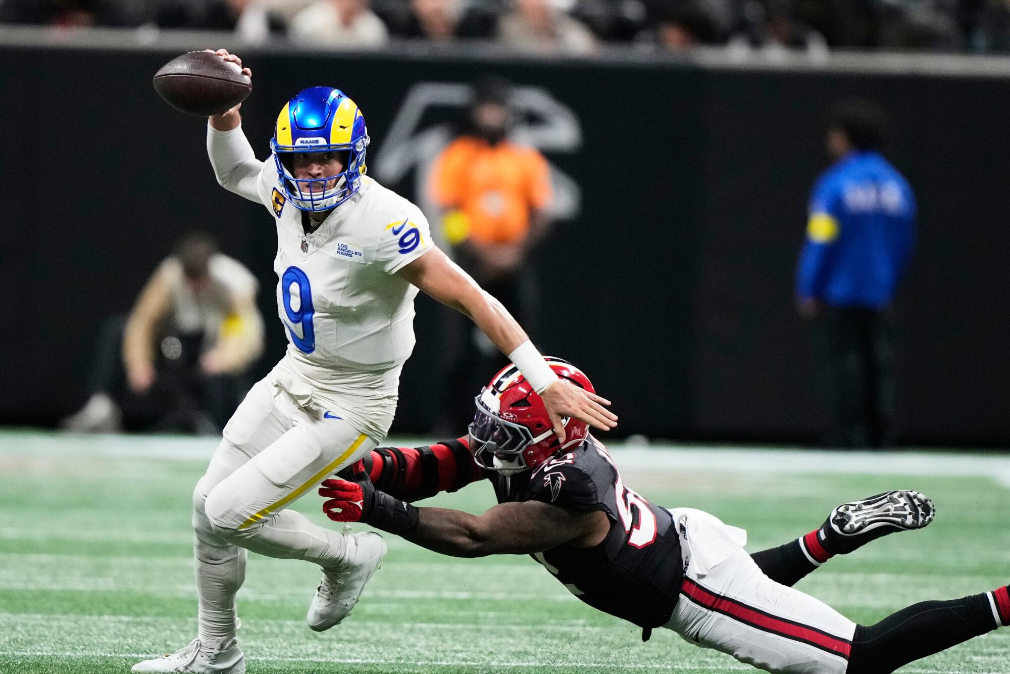 Rams quarterback Matthew Stafford tries to avoid diving Atlanta Falcons linebacker Khalid Kareem.