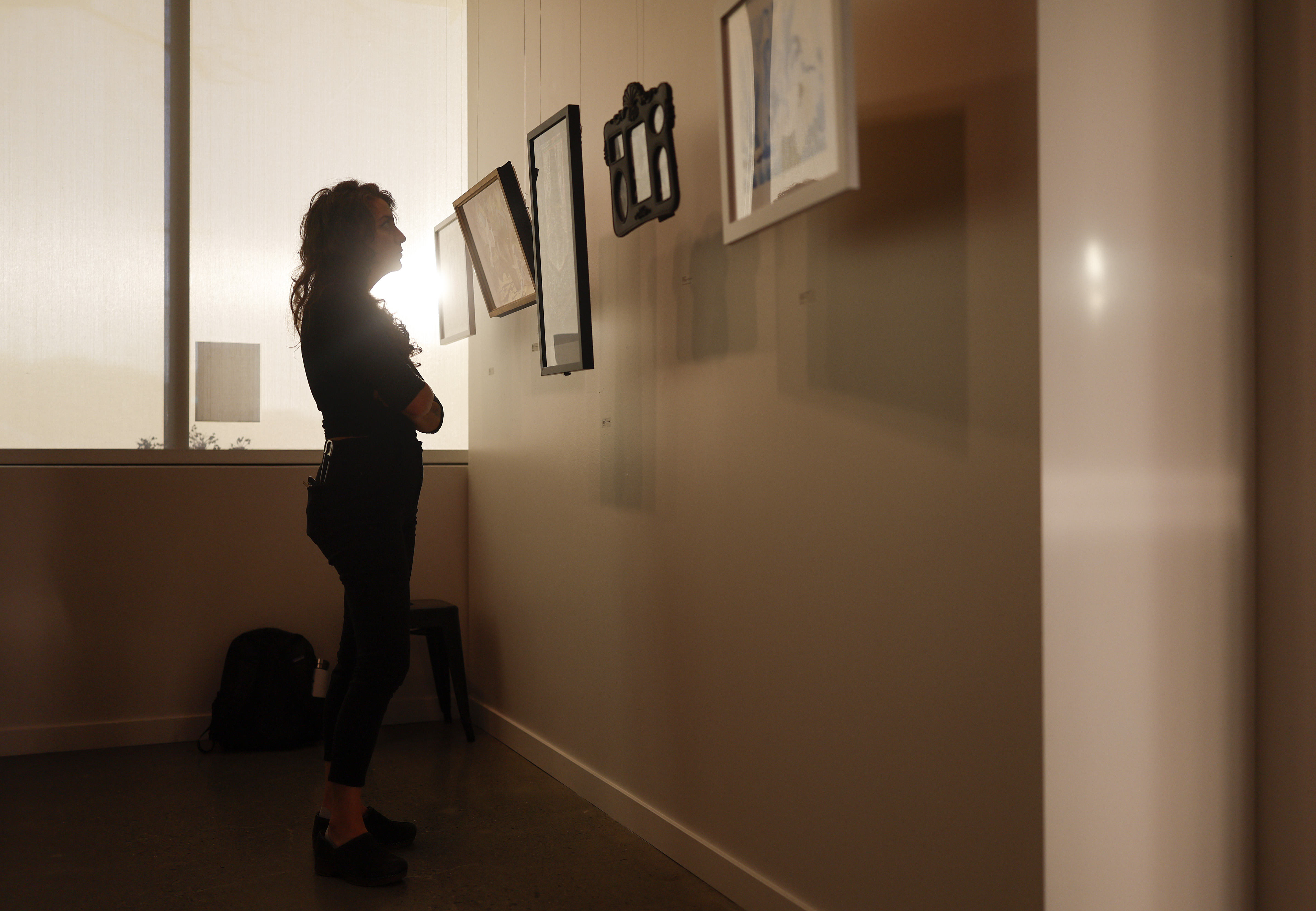 Local Color executive director Erin Salazar looks at artwork at...