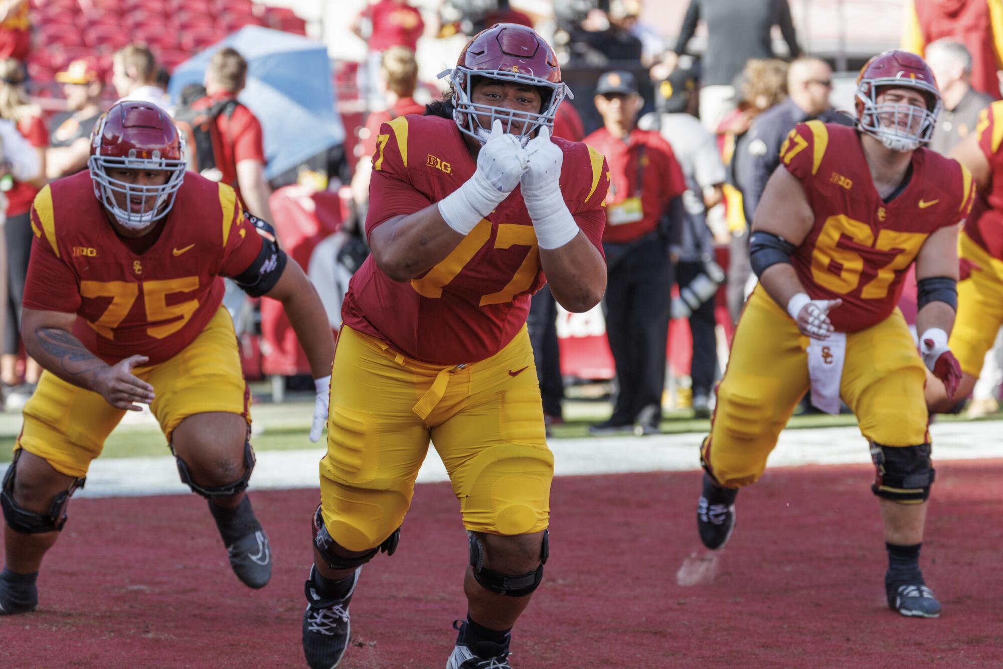 USC Trojans offensive linemen Alani Noa, Amos Talalele and Kilian O'Connor warm up before facin Notre Dame.