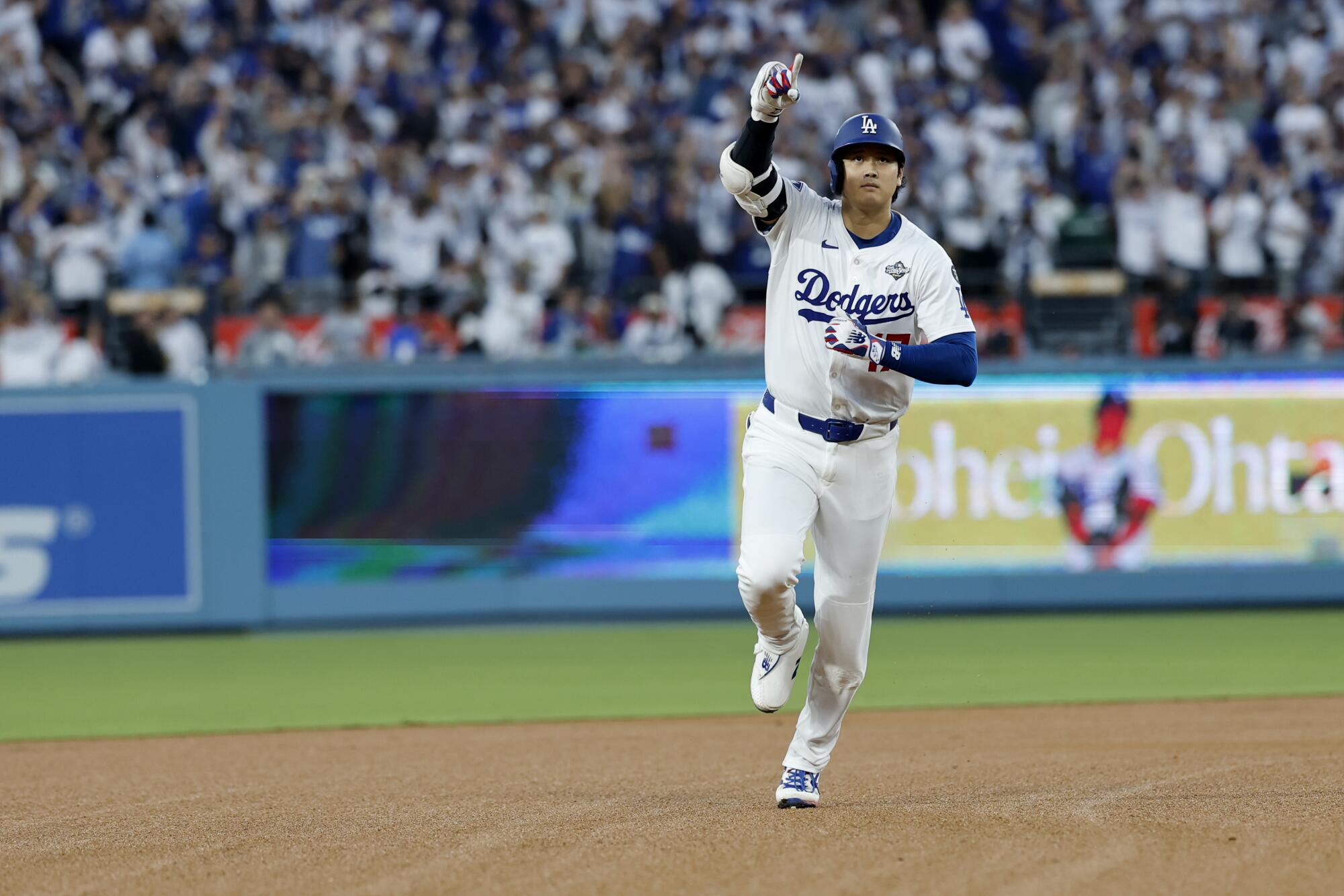 Dodgers two-way star Shohei Ohtani points as he rounds the bases after hitting a solo home run during the World Series.
