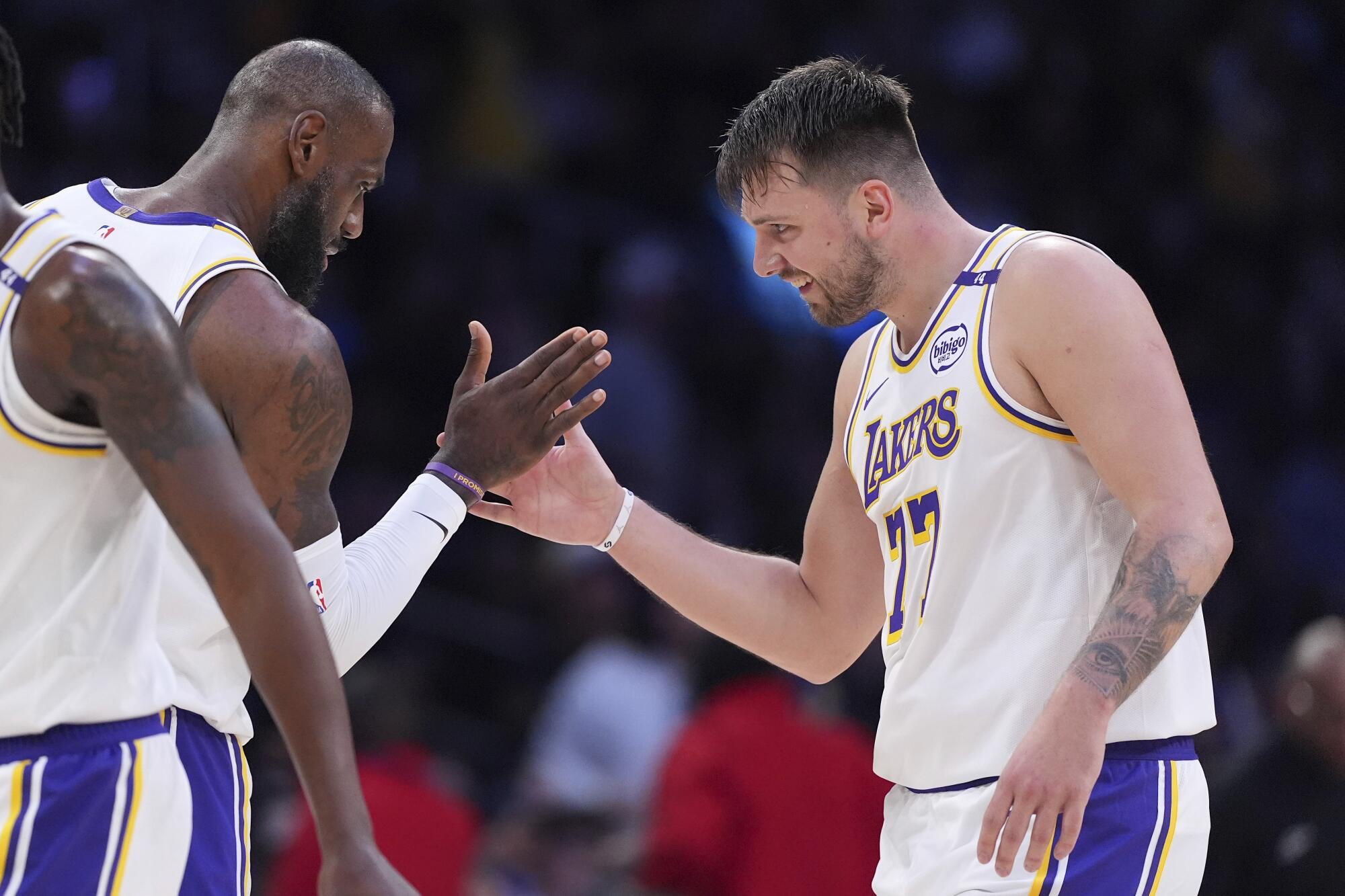 Lakers guard Luka Doncic claps hands with forward LeBron James during a game against the Clippers on March 2.