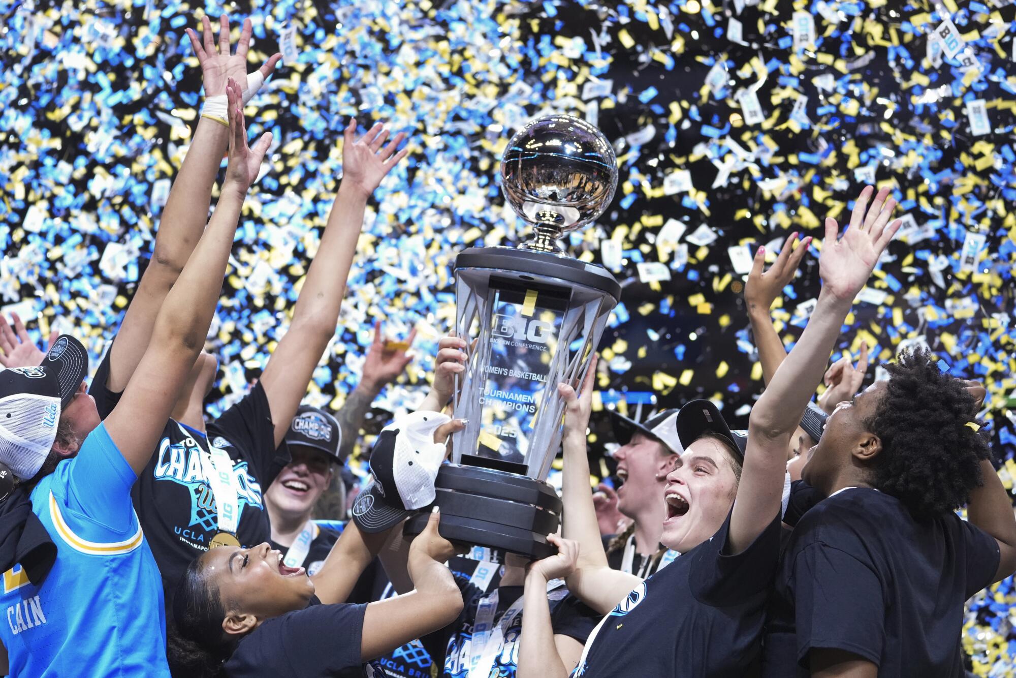 UCLA women's basketball players celebrate as confetti falls after they beat USC to win the Big Ten tournament title.