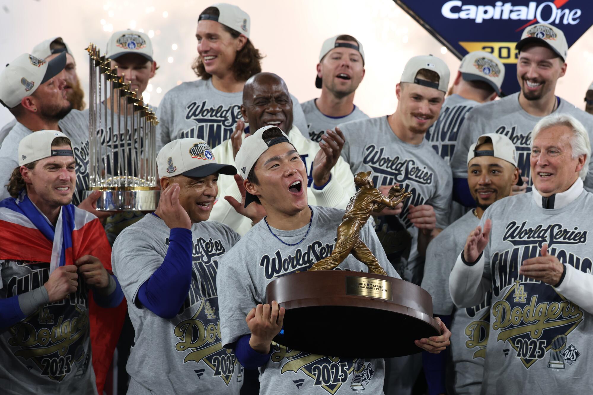 Dodgers pitcher Yoshinobu Yamamoto holds up the MVP trophy after beating the Blue Jays and winning the World Series.