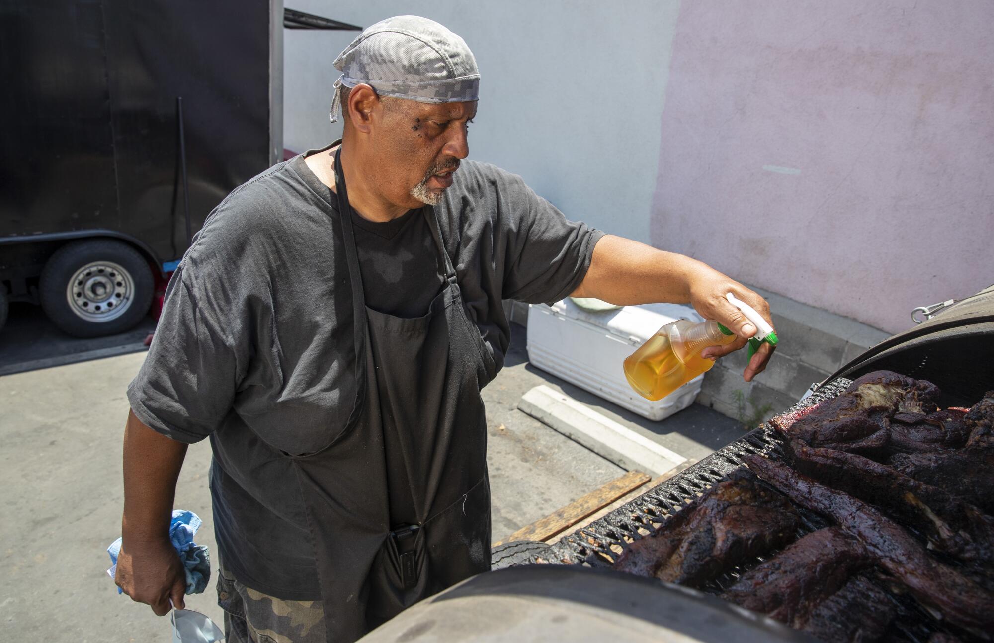 Lonnie Edwards keeps meat moist inside the pit at his RibTown BBQ in 2020.