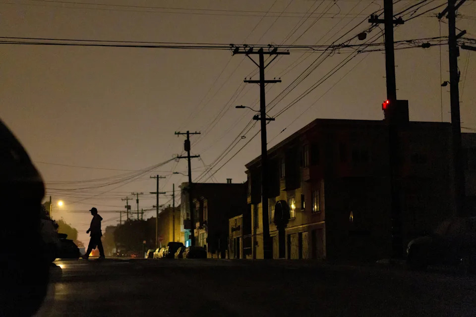 A person walks in the dark during a blackout that affected about 130,000 residents, according to the Pacific Gas and Electric Company, in San Francisco, Calif. on Dec. 21, 2025.