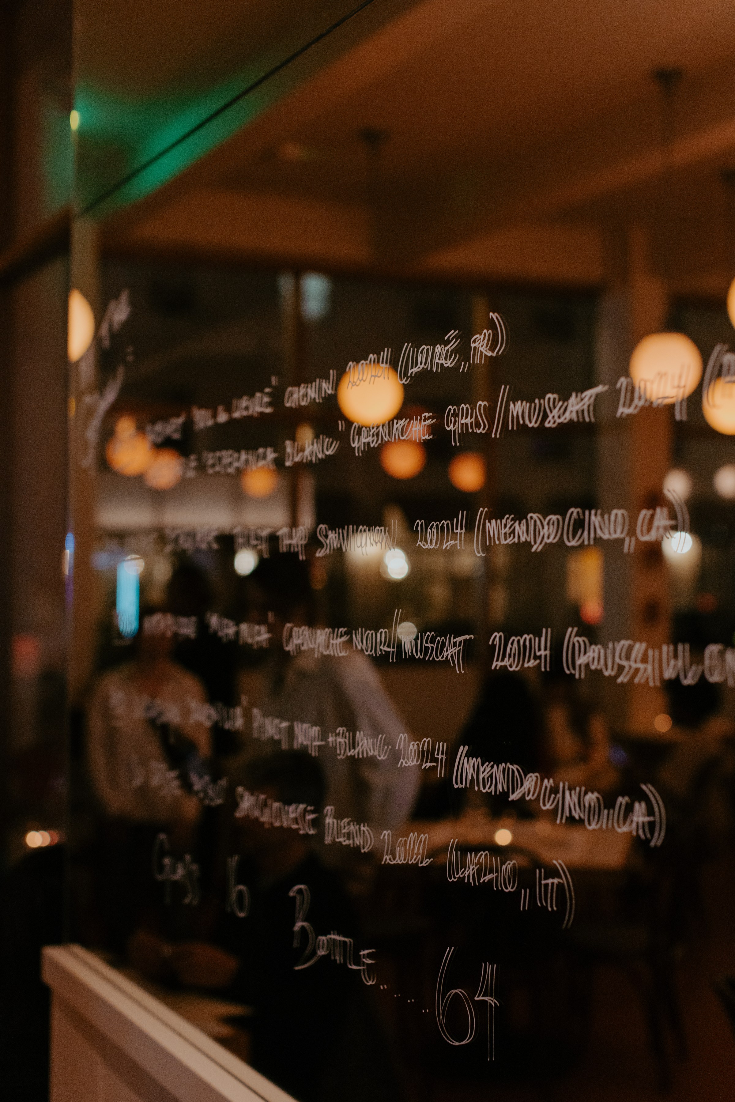 Wine list written on a mirror at Little Fish Melrose Hill.