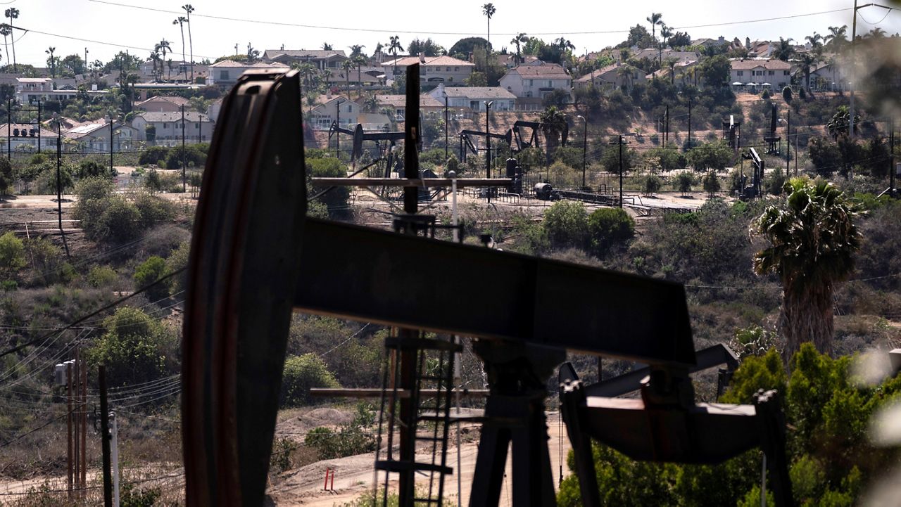 In this May 18, 2021, file photo, homes sit on a hill behind pump jacks operating at the Inglewood Oil Field in Los Angeles. (AP Photo/Jae C. Hong, File)