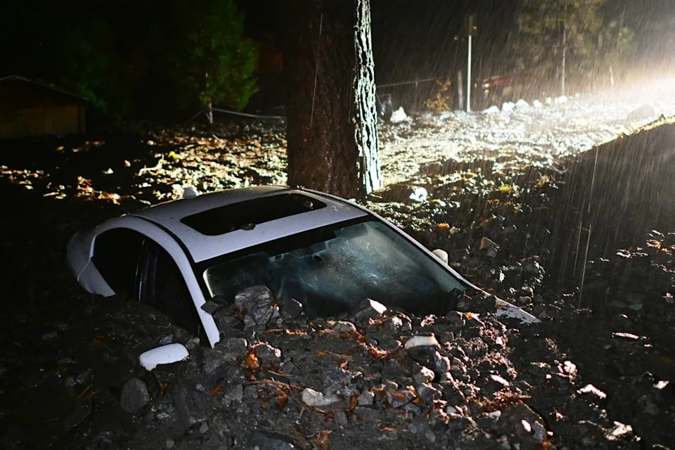 A car sits buried in mud after flooding Wednesday, Dec. 24, 2025, in Wrightwood, Calif. (AP Photo/Wally Skalij)