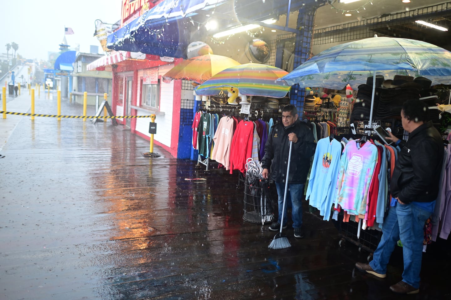 Miguel Lopez swept water from Marlene's Beachcomber on the Santa Monica pier on Wednesday in Santa Monica, Calif.