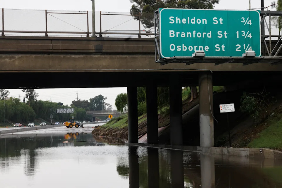 Crews work to clear a section of the 5 Freeway that was closed amid heavy rain in the Sun Valley area of Los Angeles on Dec. 24, 2025. / Credit: Jill Connelly / REUTERS