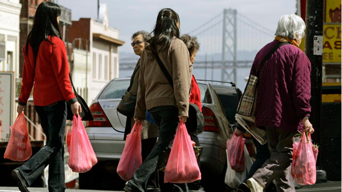FILE: Women shoppers walk with plastic bags in the Chinatown district of San Francisco. 