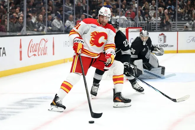 Dec 13, 2025; Los Angeles, California, USA; Calgary Flames center Nazem Kadri (91) controls the puck against Los Angeles Kings left wing Kevin Fiala (22) during the first period at Crypto.com Arena.