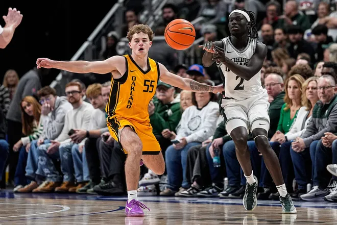 Michigan State guard Kur Teng (2) makes a pass against Oakland guard Brody Robinson (55) during the first half at Little Caesars Arena in Detroit on Saturday, Dec. 20, 2025.