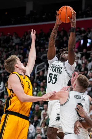 Michigan State forward Coen Carr (55) grabs a rebound against Oakland during the first half at Little Caesars Arena in Detroit on Saturday, Dec. 20, 2025.