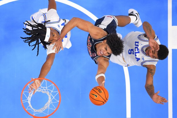 Arizona forward Koa Peat, center, shoots as UCLA forward Steven Jamerson II, left, and guard Brandon Williams defend during the second half of a Hall of Fame Series college basketball game Friday, Nov. 14, 2025, in Inglewood, Calif. (AP Photo/Mark J. Terrill)