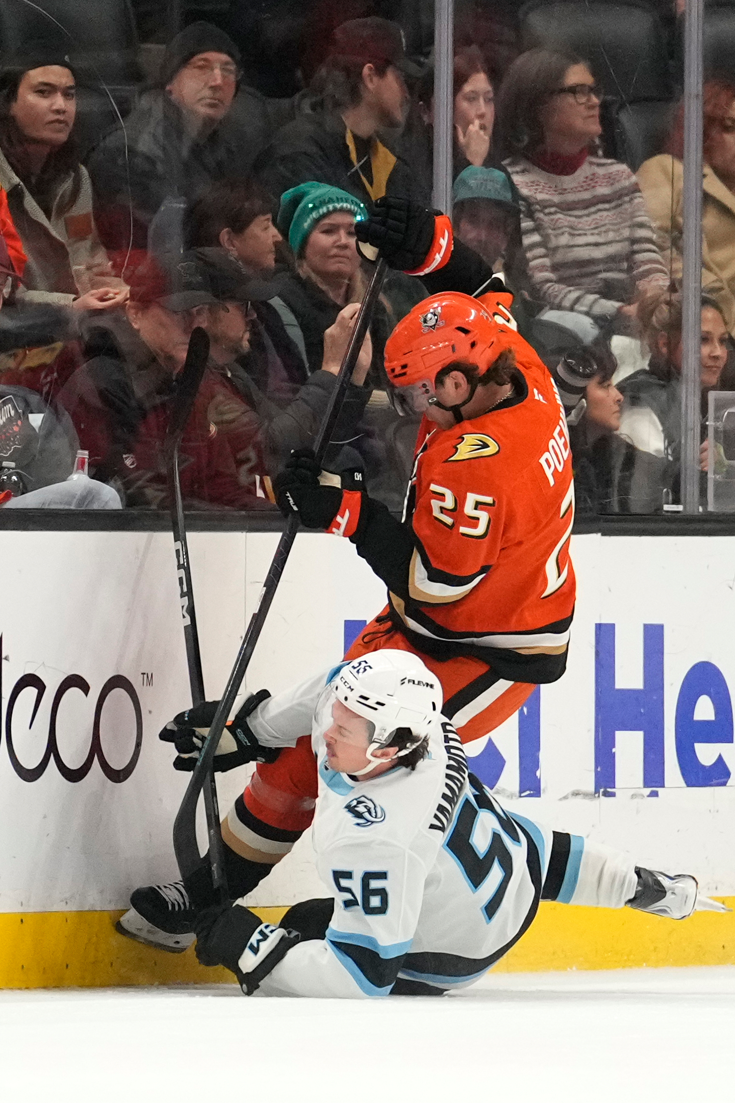 Ducks center Ryan Poehling, top, falls over Utah Mammoth right...