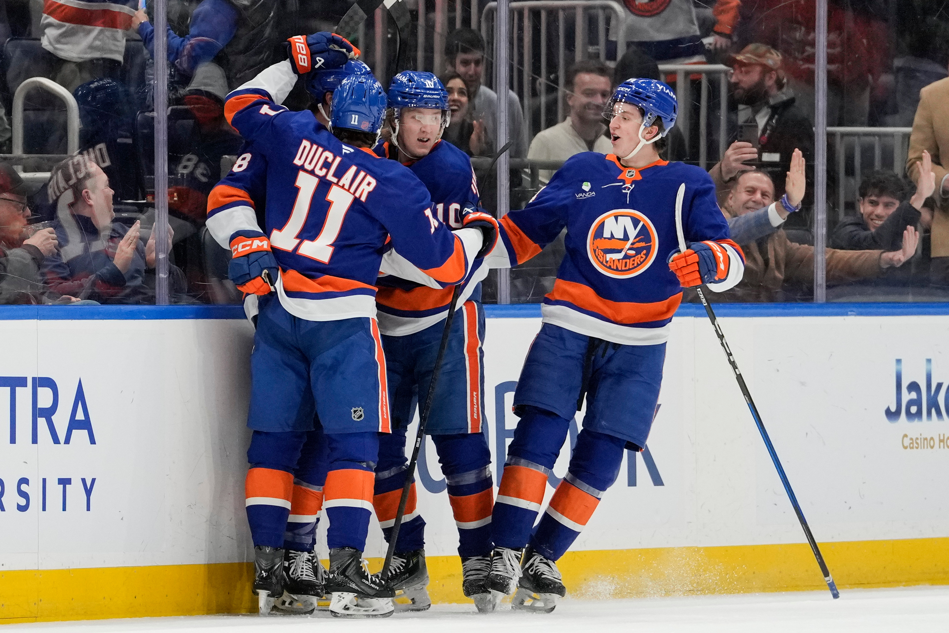 New York Islanders defenseman Travis Mitchell (38) celebrates with teammates...