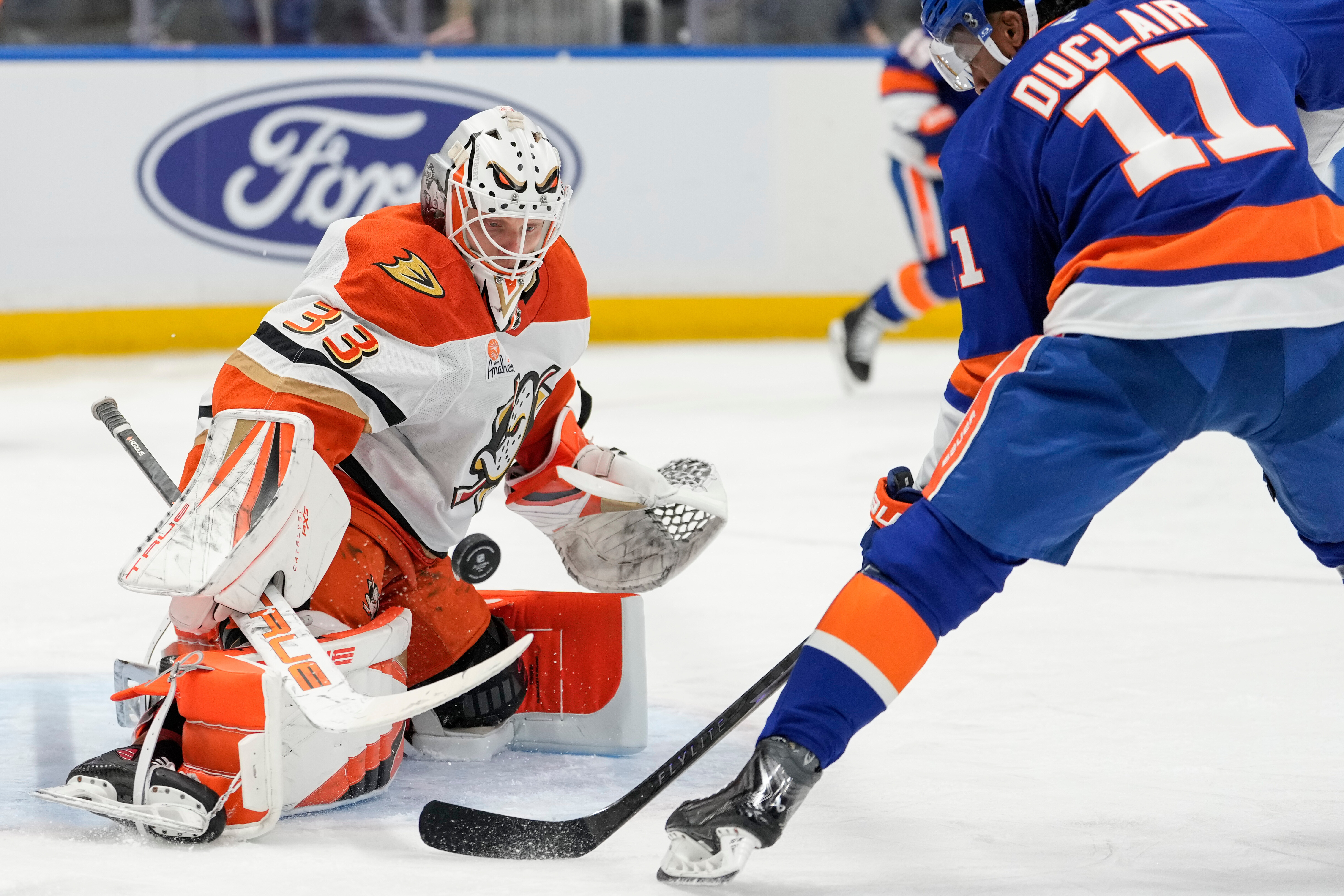 Ducks goaltender Ville Husso, left, stops a puck in front...
