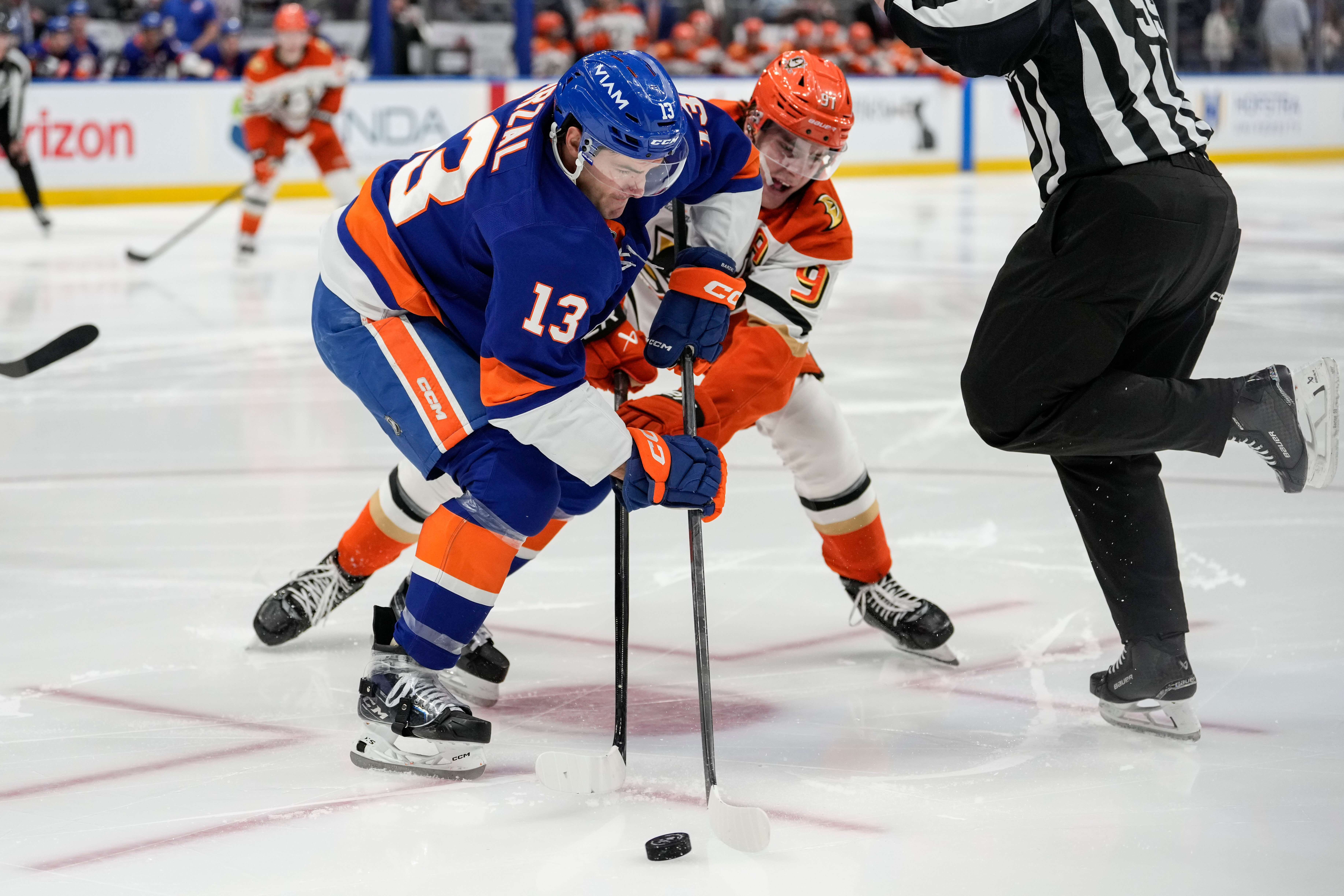 New York Islanders center Mathew Barzal, left, battles for control...