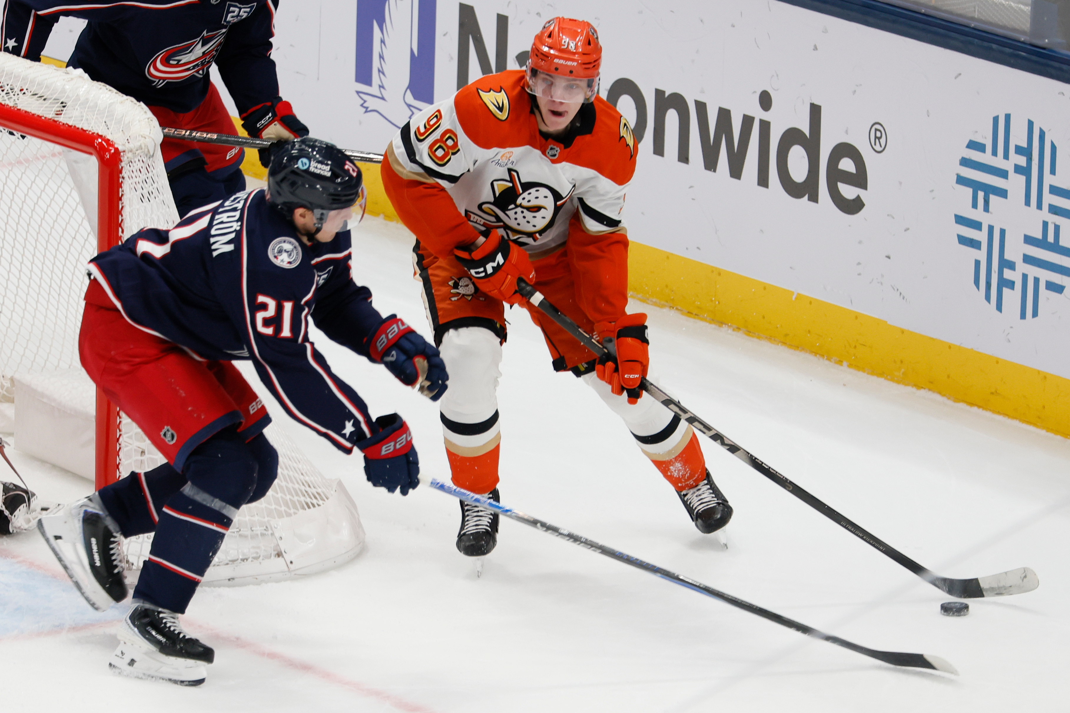The Ducks’ Pavel Mintyukov, right, looks for an open pass...