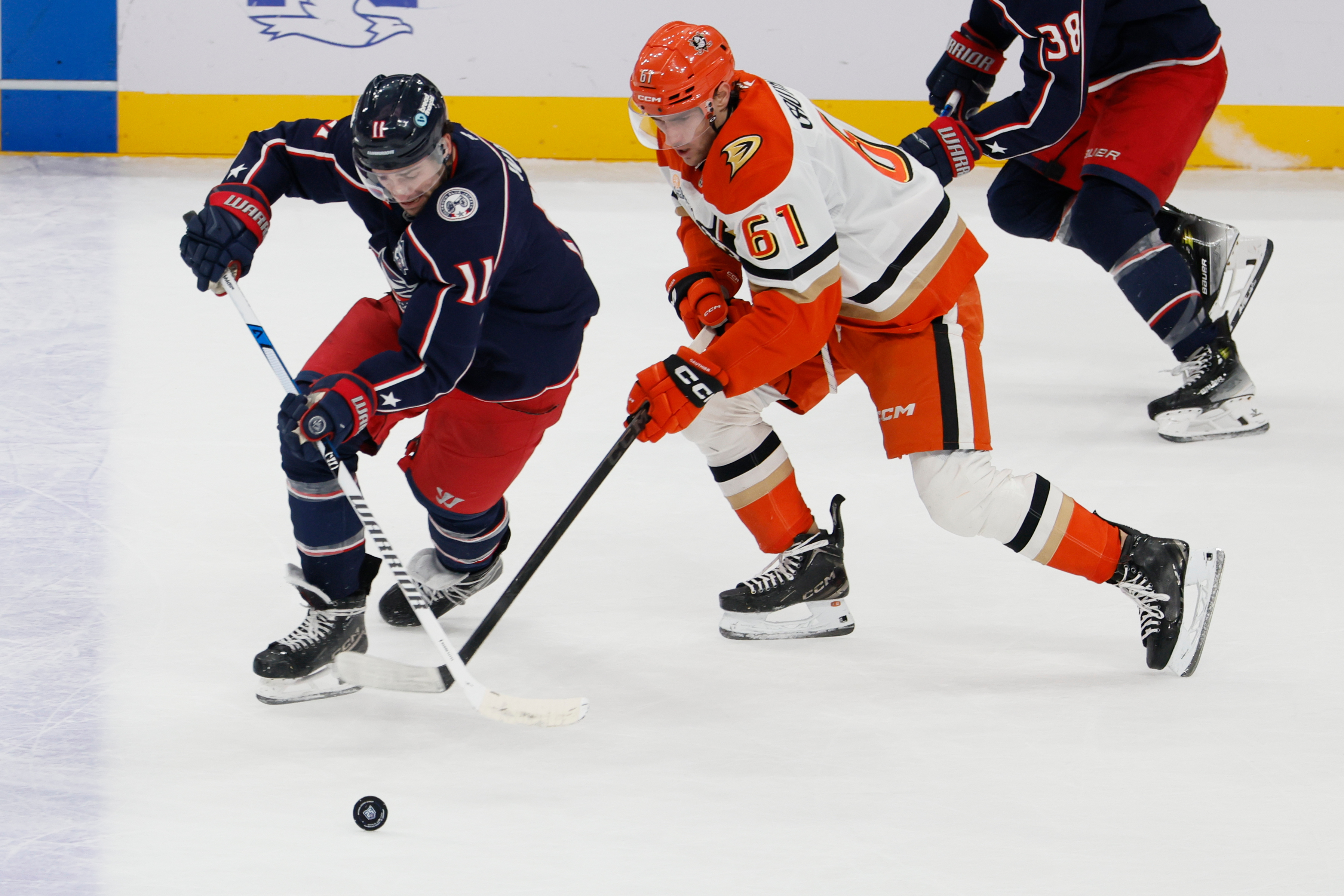 The Columbus Blue Jackets’ Miles Wood, left, and the Ducks’...