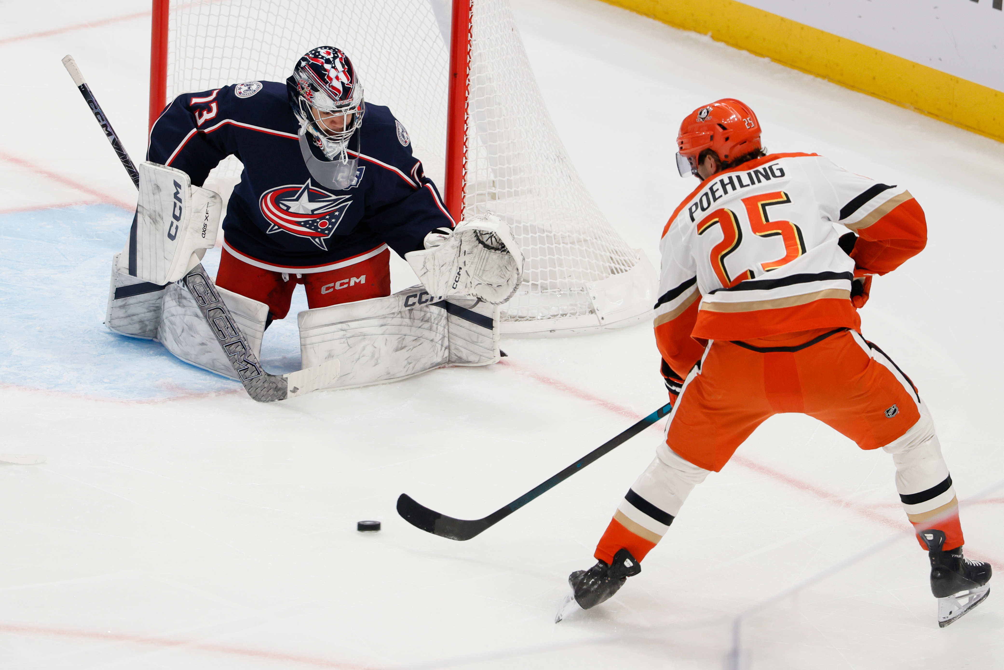 Columbus Blue Jackets goaltender Jet Greaves, left, makes a save...