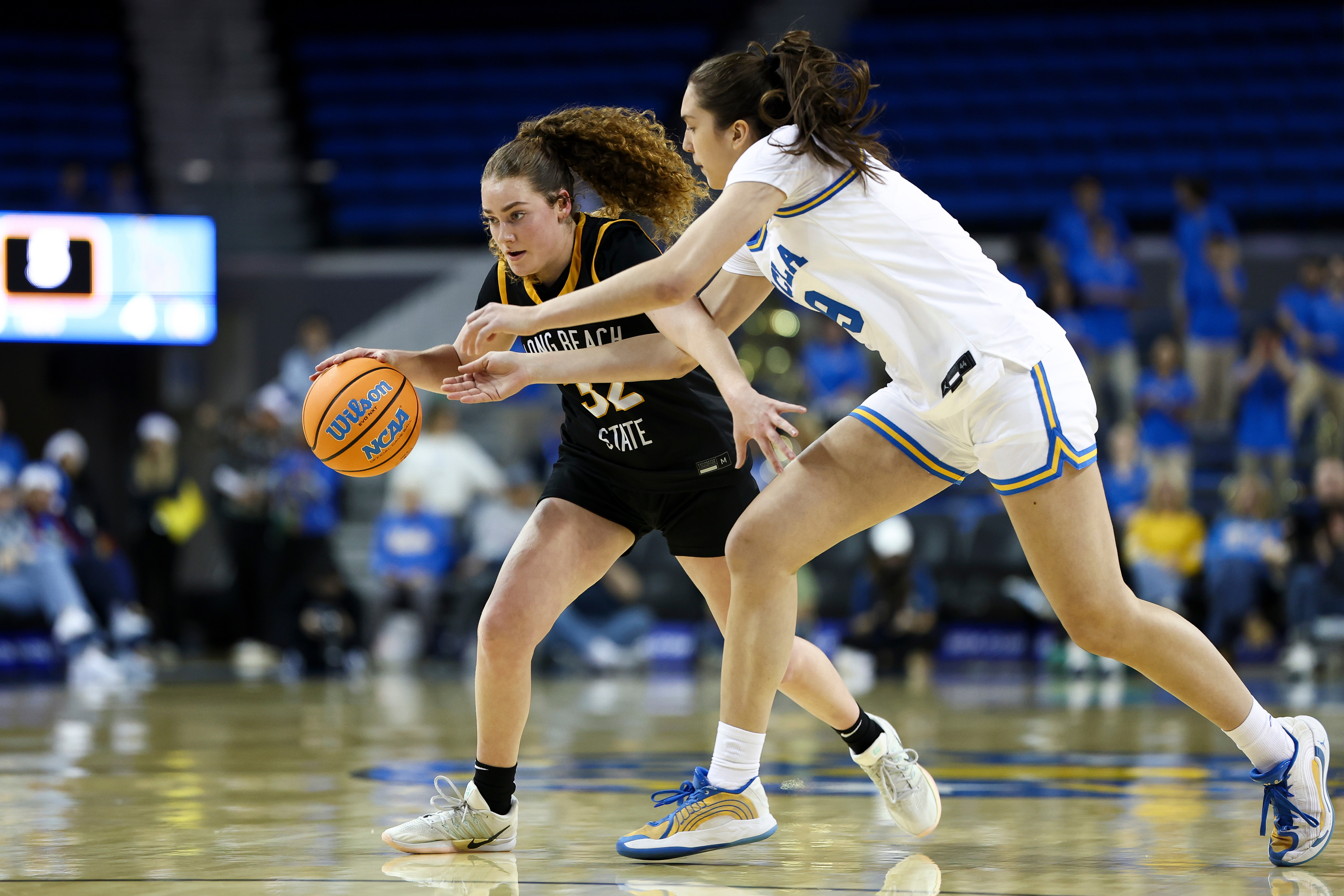 Long Beach State guard Brynna Pukis, left, drives against UCLA...