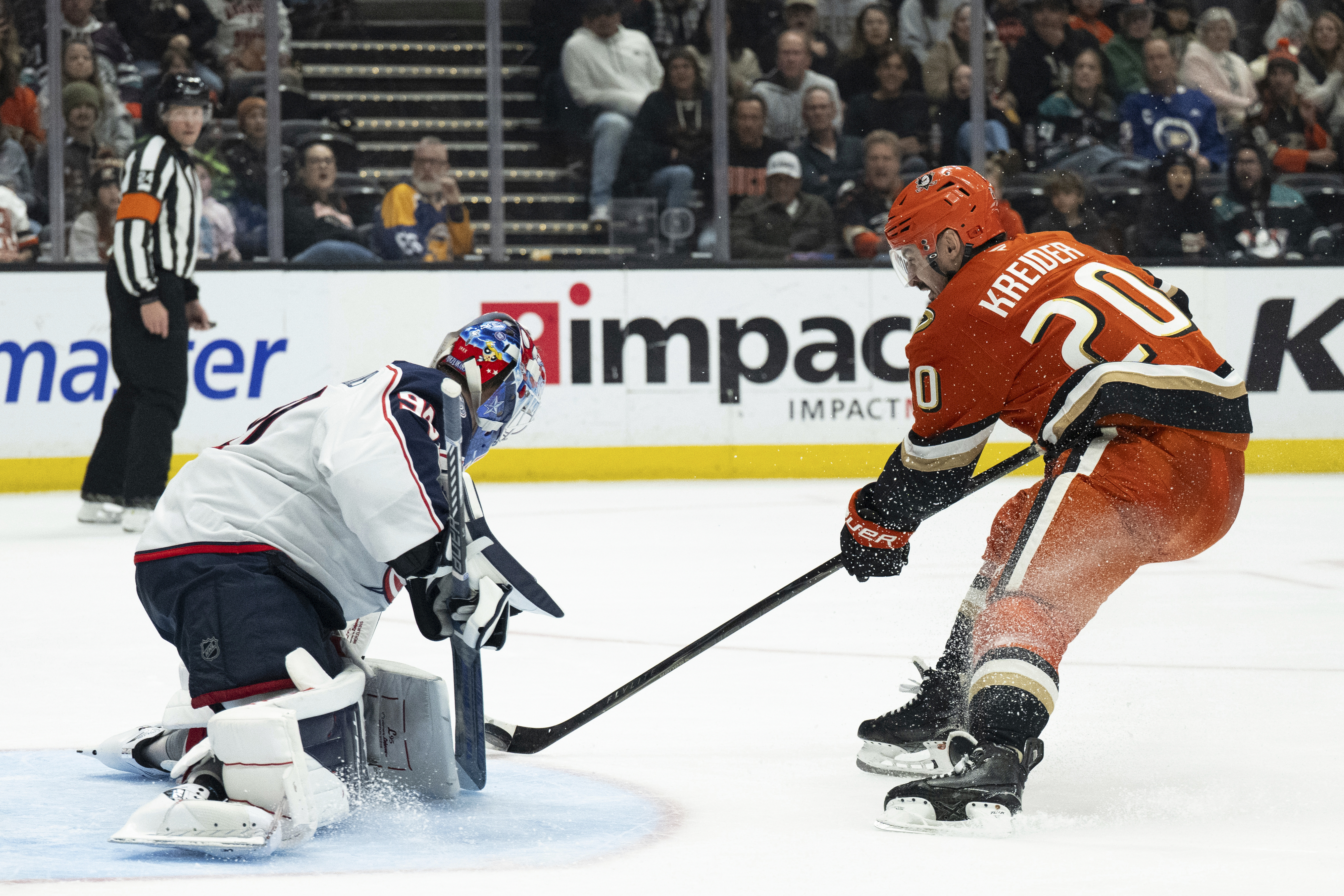 Columbus Blue Jackets goaltender Elvis Merzlikins, left, blocks a shot...