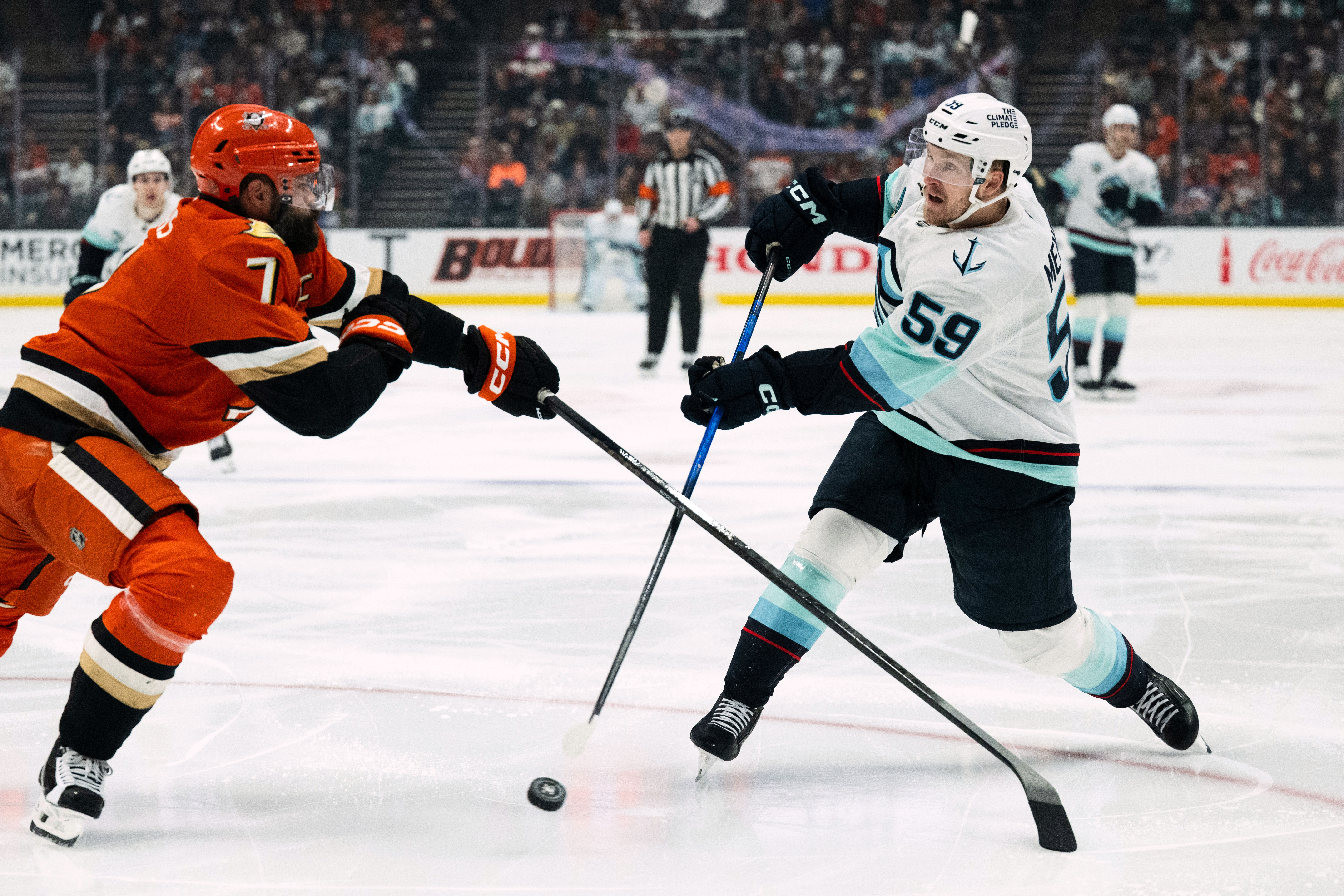 Seattle Kraken center Ben Meyers, right, shoots the puck as...
