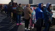 People wait in line to buy masa, a dough used to make tamales, outside Amapola Market in Downey, Calif., early Tuesday morning, Dec. 23, 2025. 