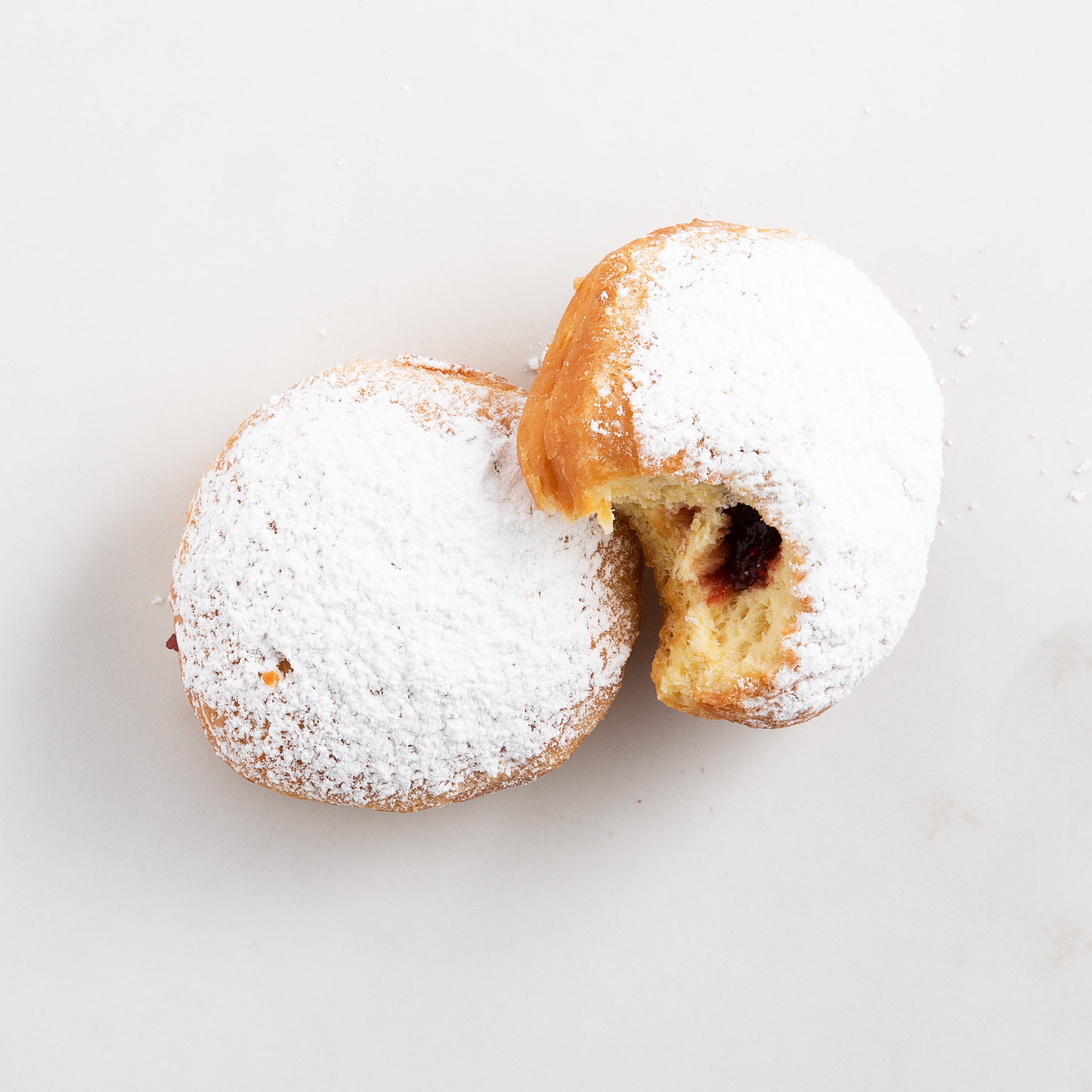 Two powdered, jelly-filled sufganiyot.