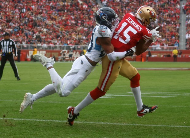 San Francisco 49ers' Jauan Jennings (15) make a catch for a touchdown against Tennessee Titans' Kevin Winston Jr. (23) in the second quarter at Levi's Stadium in Santa Clara, Calif., on Sunday, Dec. 14, 2025. (Nhat V. Meyer/Bay Area News Group)