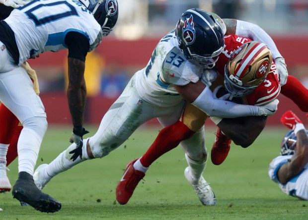 San Francisco 49ers' Brian Robinson Jr. (3) is tackled by Tennessee Titans' Cedric Gray (33) in the third quarter at Levi's Stadium in Santa Clara, Calif., on Sunday, Dec. 14, 2025. (Nhat V. Meyer/Bay Area News Group)