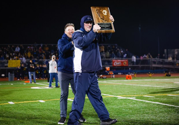 Lincoln's head coach of 33 years Kevin Collins lifts up the trophy while Lincoln celebrates winning against Gridley during the CIF NorCal championship game at Lincoln High School in San Jose, Calif., on Friday, Dec. 5, 2025. (Shae Hammond/Bay Area News Group)