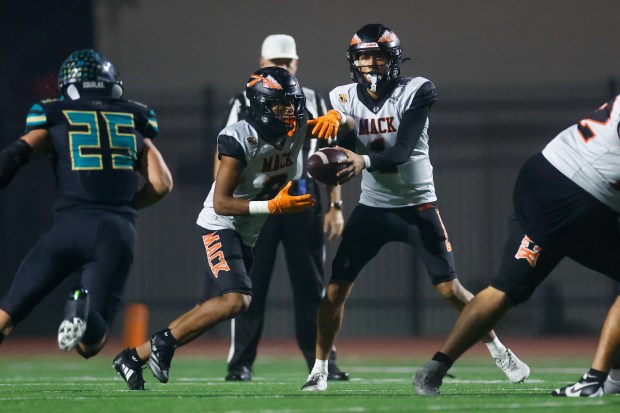 McClymonds' Berell Staples (1) hands the ball to McClymonds' Dominic Davis (8) in the first quarter during Division 3-A state championship football game at Fullerton Union High School District Stadium in Fullerton, Calif., on Saturday, Dec. 13, 2025. (Shae Hammond/Bay Area News Group)